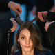 A model has makeup applied and her hair done backstage before the Rodarte Fall/Winter 2015 collection show.